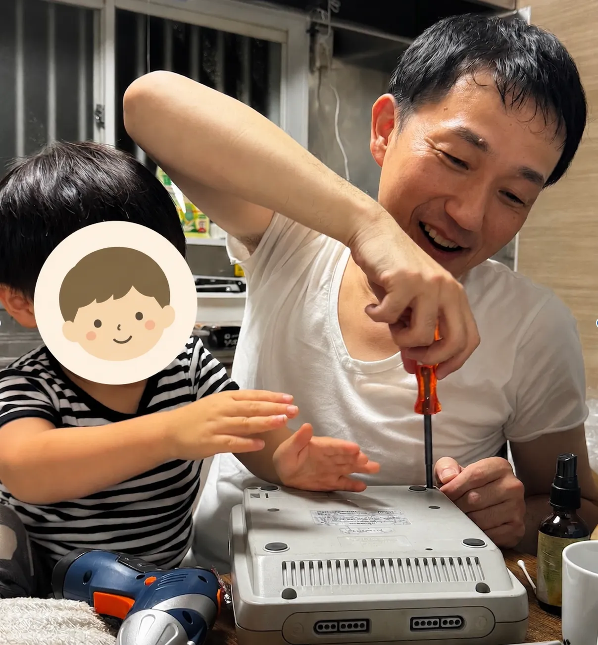 運営者・伊藤が自宅で子どもと一緒にレトロゲーム機を修理している様子